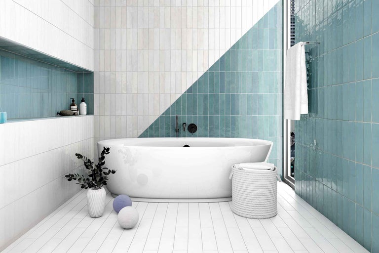 Baie modernă cu faianță albă și verde, cadă independentă și elemente decorative.