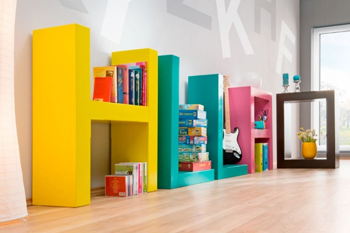 Raft decorativ în formă de litere cu cărți și elemente decorative în cameră.