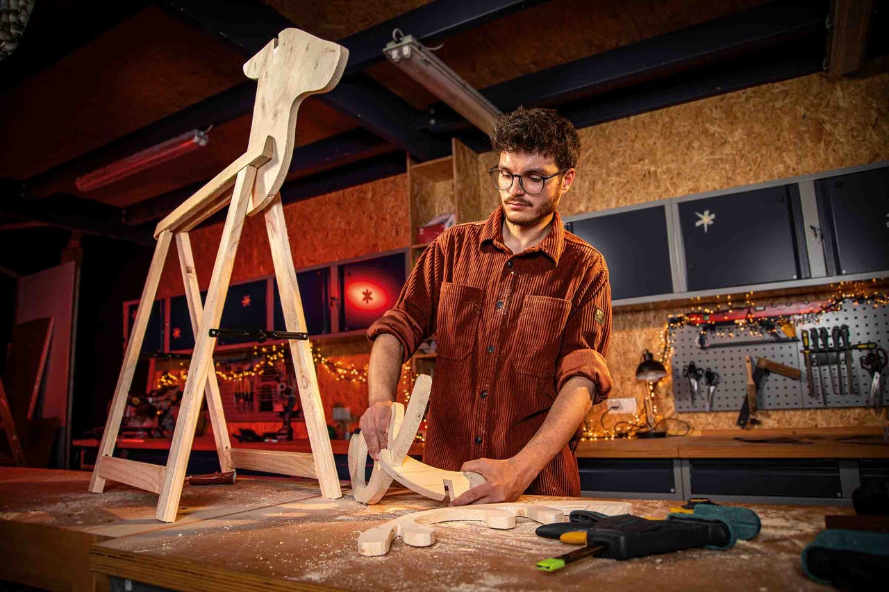 Bărbat construind un cal balansoar din lemn în atelier