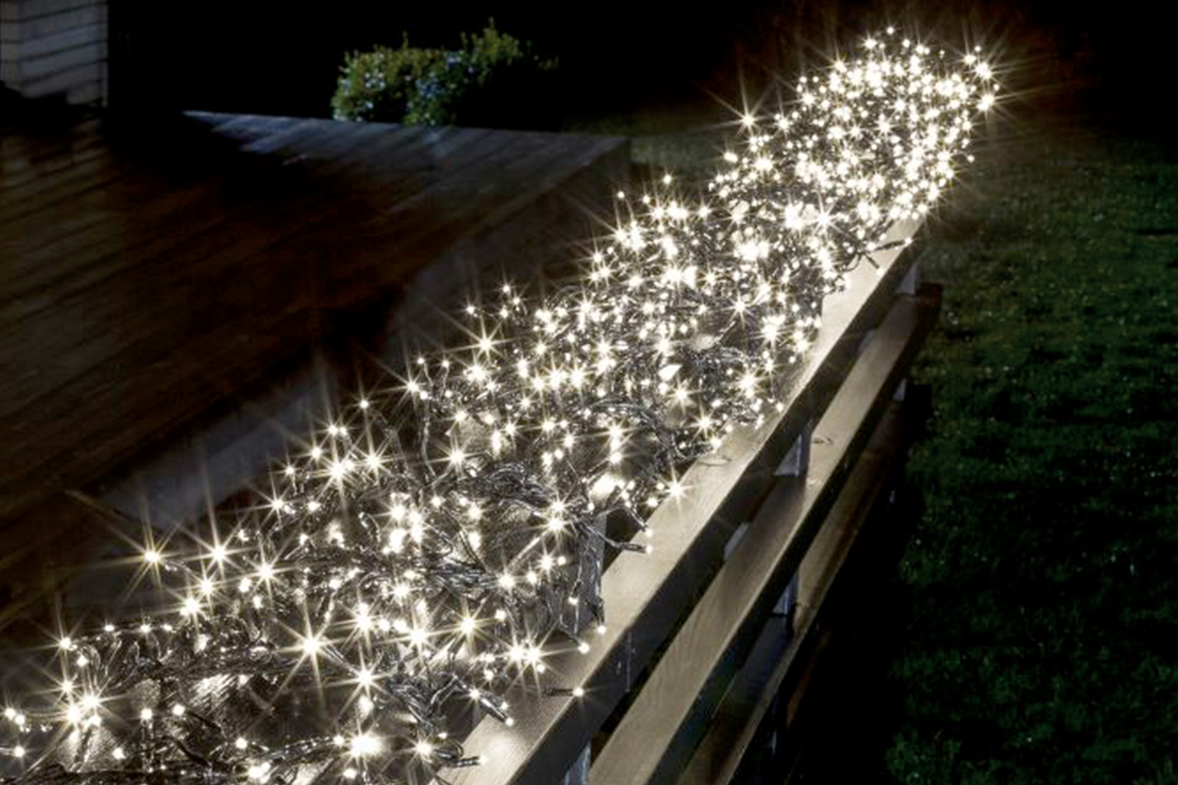 Ghirlandă luminoasă decorativă pe un gard la exterior