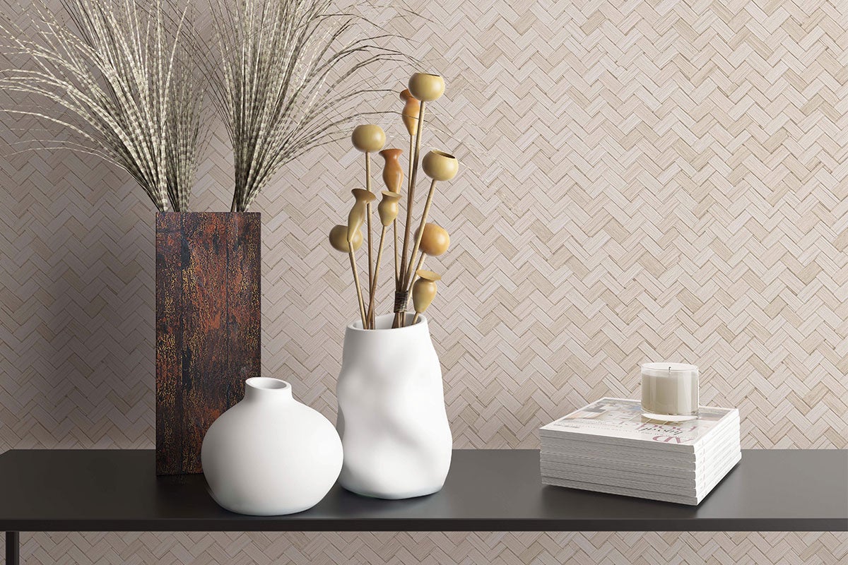 Scenă decorativă cu vaze, flori uscate, reviste și lumânare pe o masă.