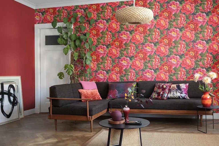 Living cu tapetă florală, canapea, masă și decorațiuni pentru o atmosferă confortabilă