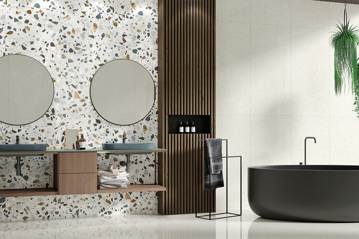 Baie modernă cu gresie tip terrazzo pe pereți și podea, chiuvetă dublă și cadă independentă