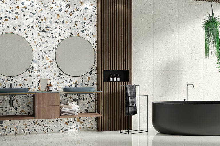 Baie modernă cu gresie tip terrazzo pe pereți și podea, chiuvetă dublă și cadă independentă