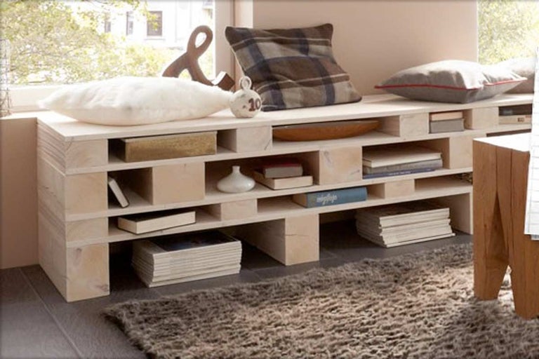 Raft din paleți de lemn cu perne, decorațiuni și covor