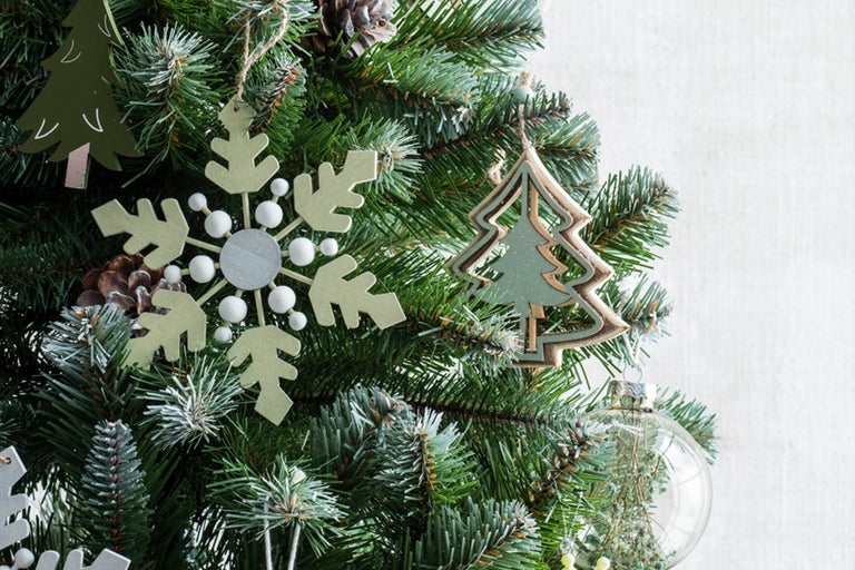 Brad împodobit cu ornamente în formă de fulgi de zăpadă și brazi de Crăciun.