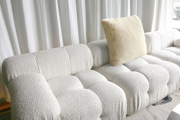 Canapea modulară albă cu pernă în fața perdelei