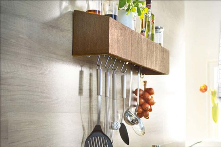 Raft de bucătărie cu ustensile de bucătărie și alimente pe perete