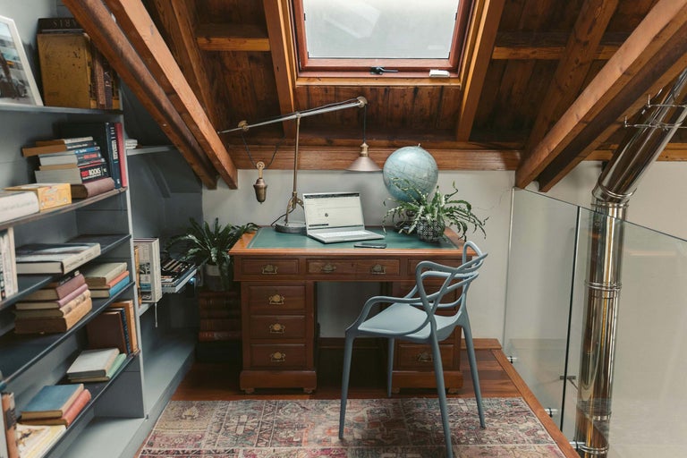 Birou cu masă de scris, scaun, bibliotecă și fereastră de mansardă
