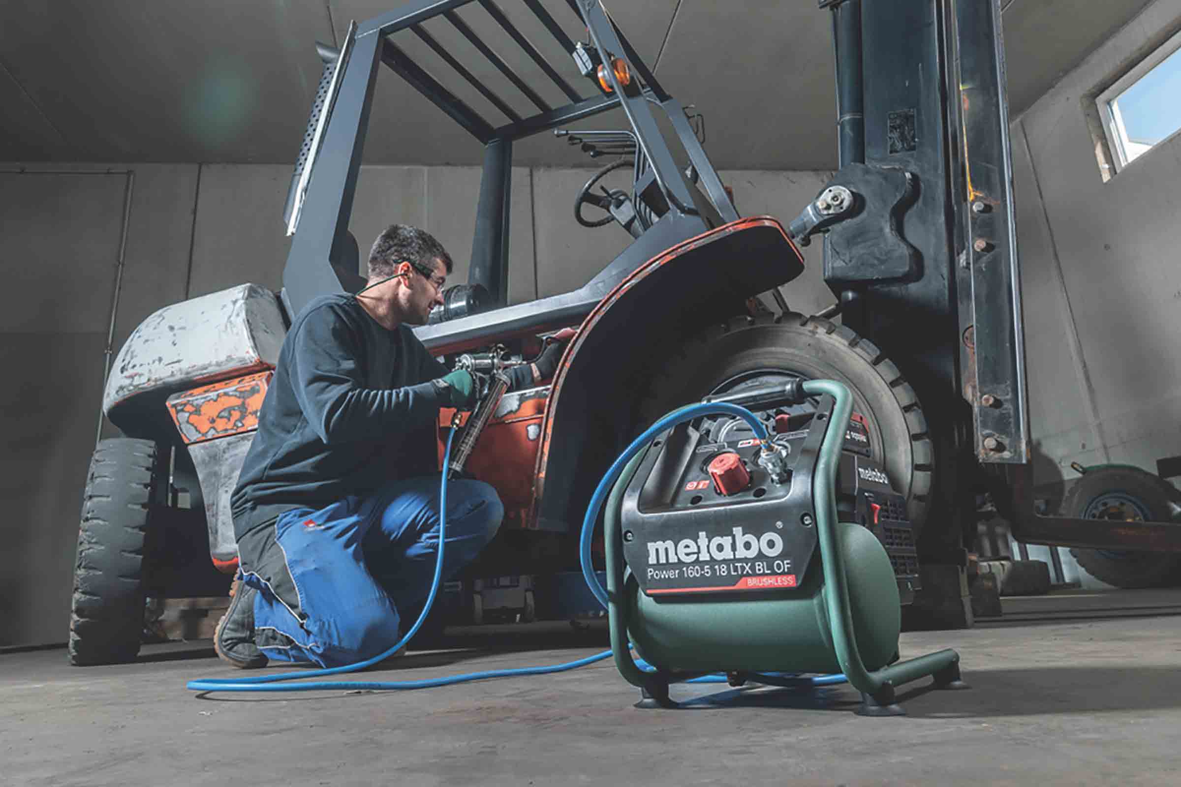 Un bărbat lucrează la un stivuitor cu un compresor cu acumulator Metabo Power 160-5 18 LTX BL OF.