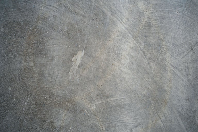 Suprafață de beton texturată cu urme vizibile de ștergere și textură neuniformă