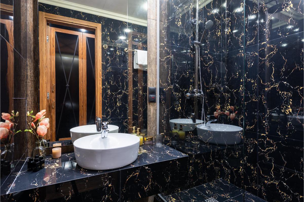 Baie modernă cu marmură neagră, chiuvetă și duș