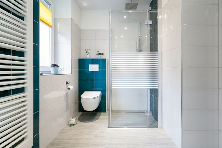 Baie modernă cu duș, toaletă și radiator
