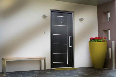 Spațiu de intrare cu o ușă de intrare modernă, o bancă și un ghiveci de flori