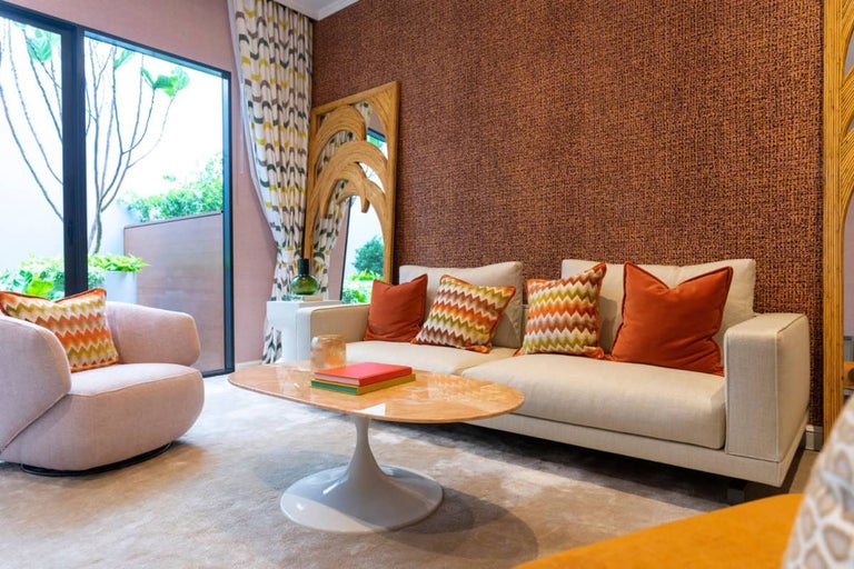Living luminos cu canapea, fotoliu, măsuță de cafea și accesorii decorative pentru o ambianță confortabilă.