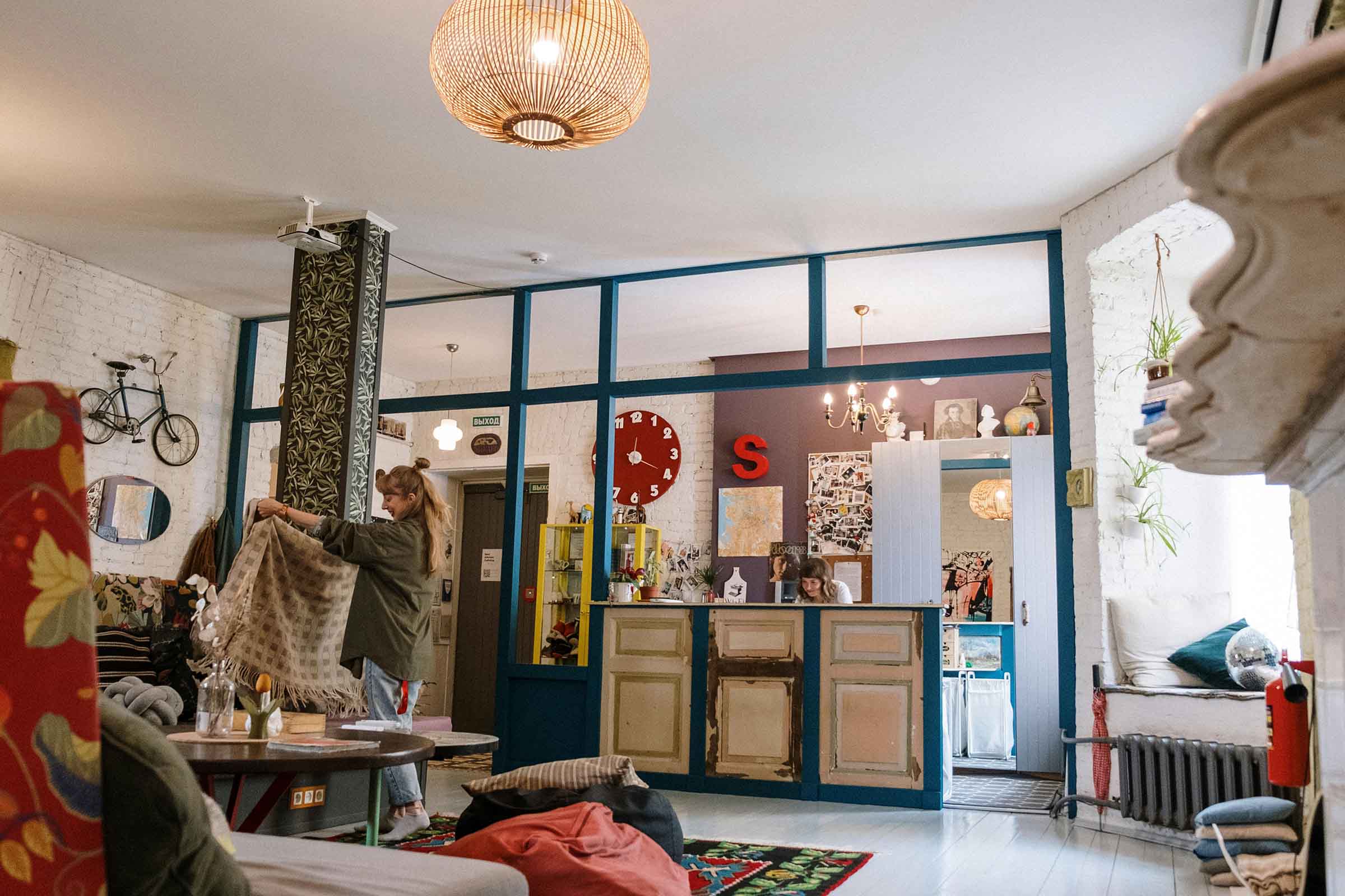 Cameră luminoasă cu decorațiuni, mobilier și o femeie ținând o pătură