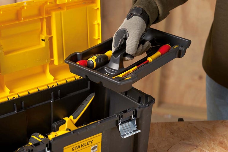 Cutie de scule deschisă cu unelte și o persoană care ridică tava de scule detașabilă
