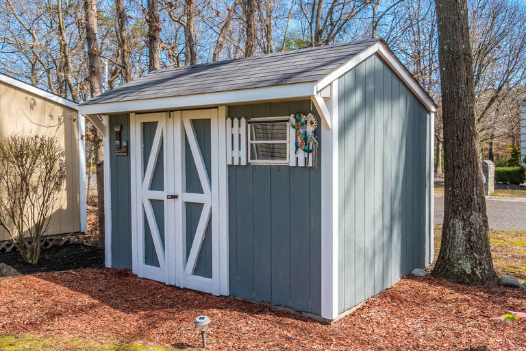 Cabana de grădină cu ușă dublă și fereastră mică în grădină.