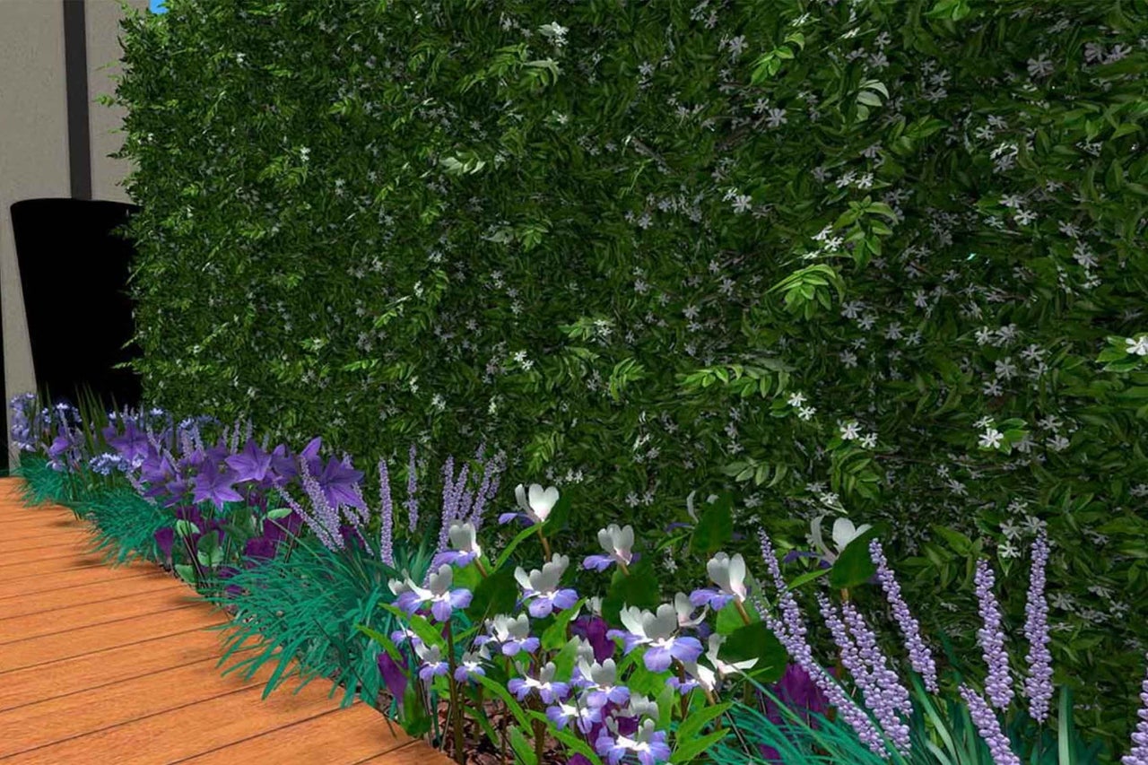 Gard viu cu flori albe și strat de flori violete lângă o terasă de lemn.