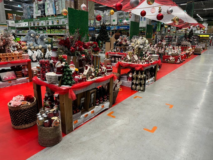 Decorațiuni de Crăciun într-un magazin Hornbach cu pomi de Crăciun, ornamente și figurine
