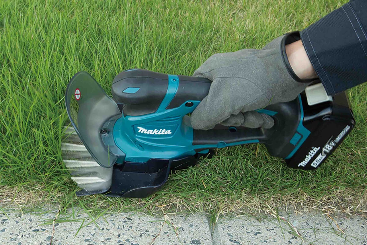 Mașină de tuns iarba cu acumulator Makita în funcțiune pe iarbă