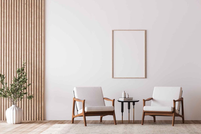 Living luminos cu două fotolii, măsuță, decorațiuni și panou de lemn pe perete