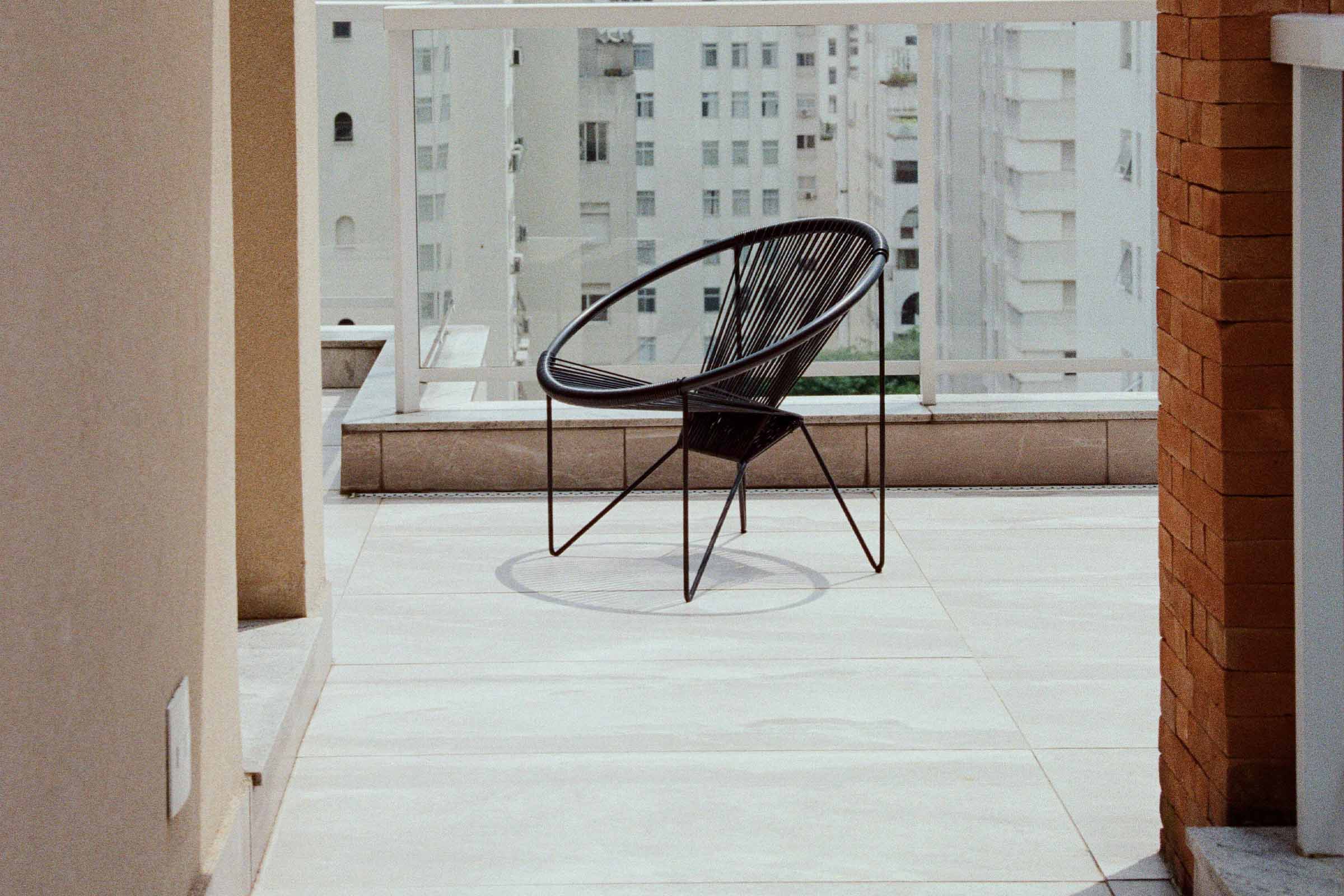 Scaun negru din ratan pe un balcon