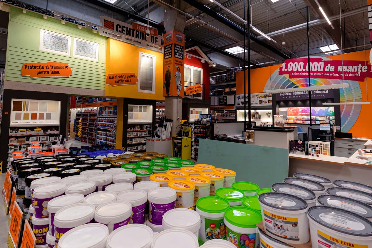 Imagine de interior a unui magazin Hornbach cu rafturi și recipiente cu vopsea
