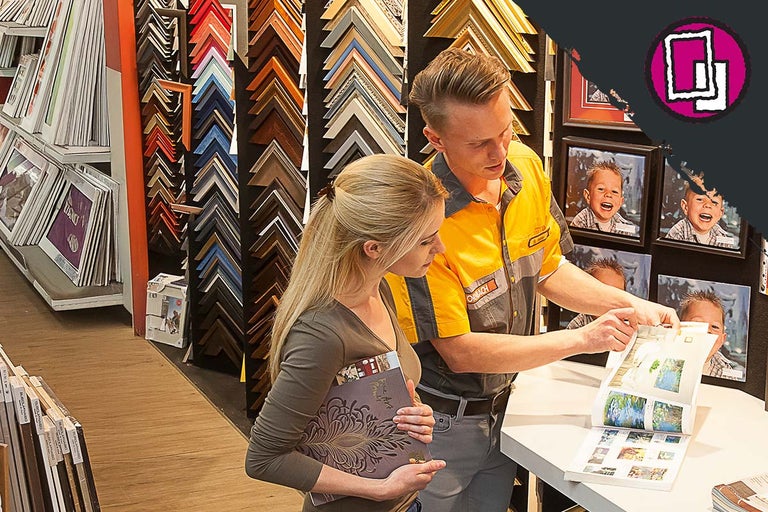 Clientă și angajat Hornbach selectând rame foto în magazinul Hornbach