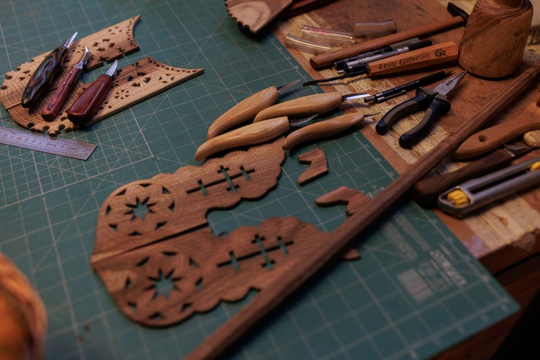 Banc de lucru cu unelte de prelucrare a lemnului și piese din lemn sculptate