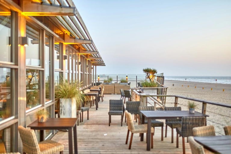 Terasa restaurantului cu mese, scaune și vedere la mare