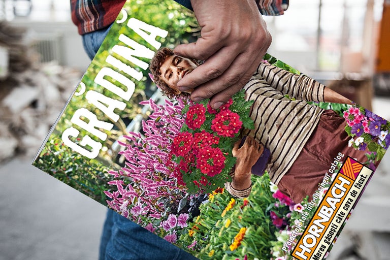 O persoană ține catalogul de grădină Hornbach cu titlul Gradina și Hornbach Logo.