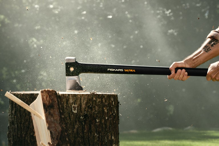 Topor Fiskars Ultra despicând lemn pe un butuc de copac