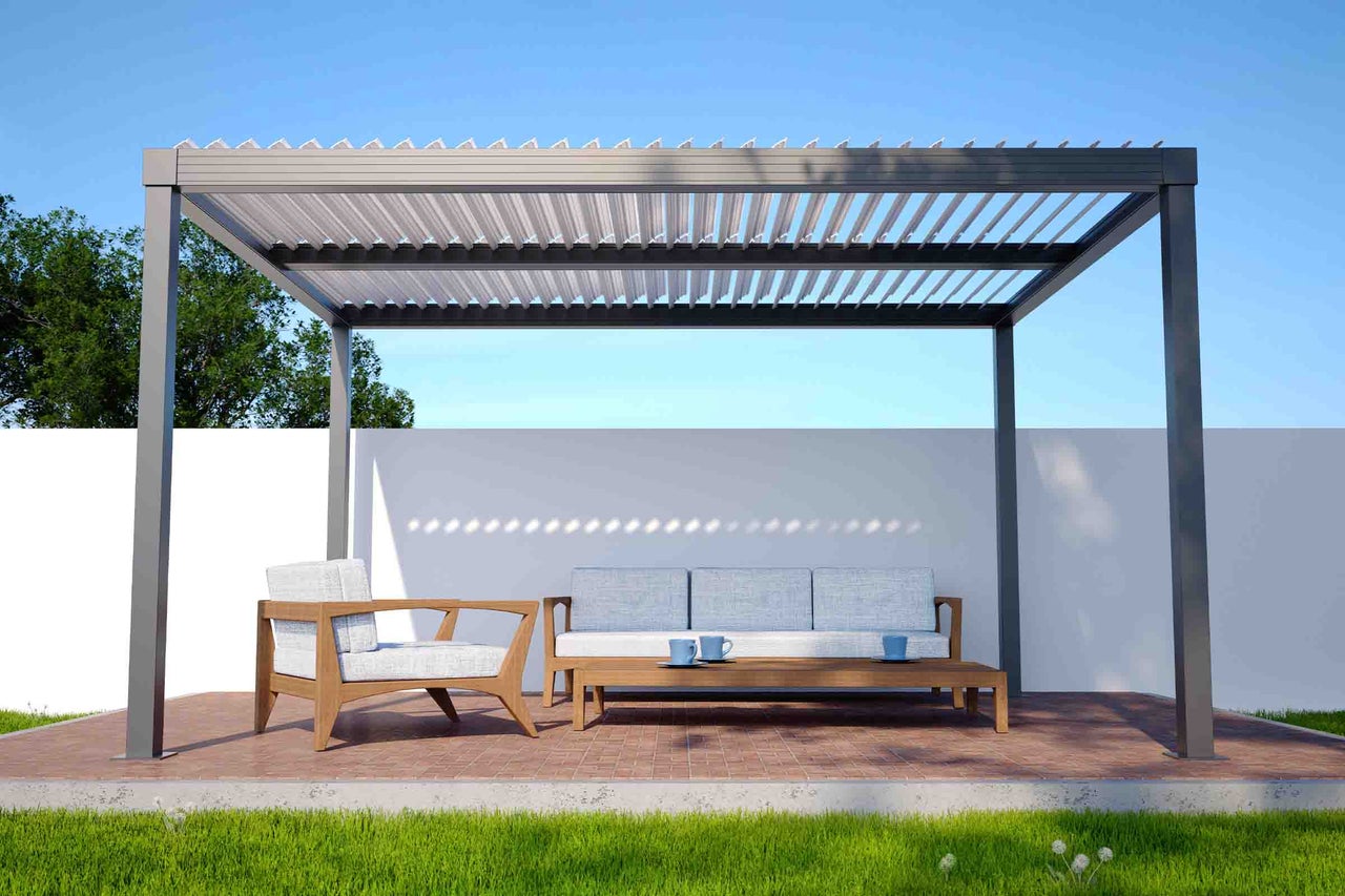 Pergolă gri închis cu acoperiș cu lamele peste mobilier de grădină din lemn pe o terasă pavată.
