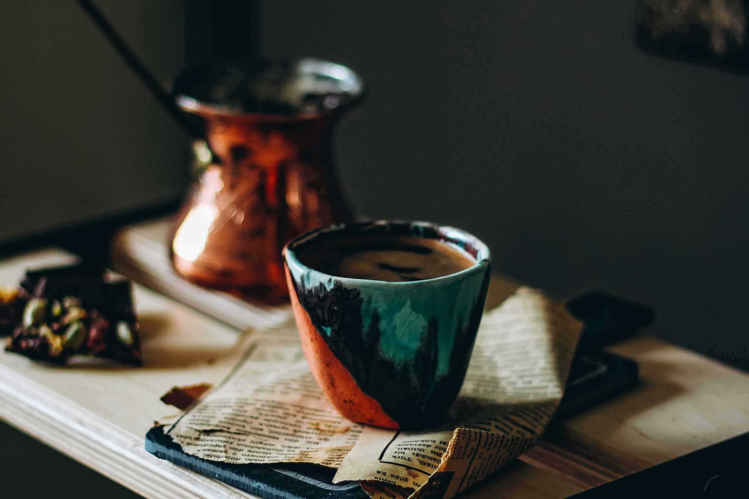 Cana de cafea și ibric turcesc pe o grămadă de ziare