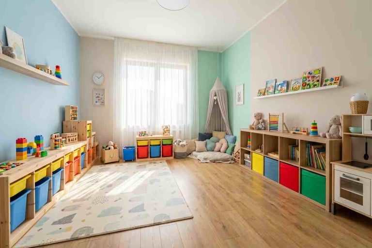Cameră de joacă pentru copii luminoasă și organizată, cu parchet laminat deschis la culoare, pereți colorați și rafturi de depozitare.