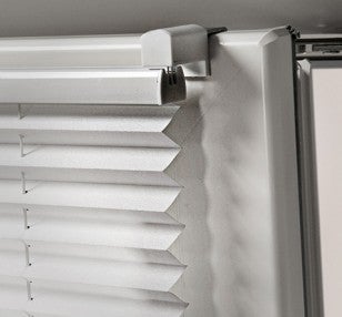 Vizualizare detaliată a unui jaluzele plisate albe pe fereastră