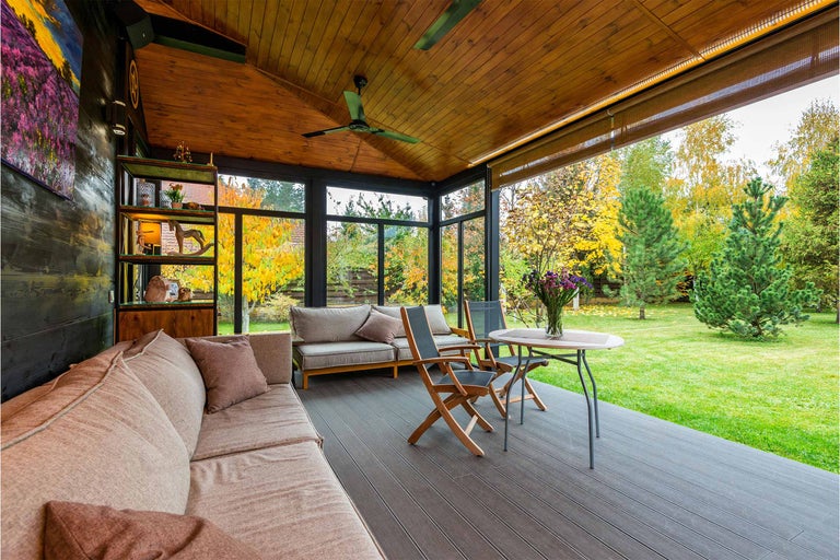Terasa acoperită cu tavan din lemn, mobilier de lounge și vedere la grădină
