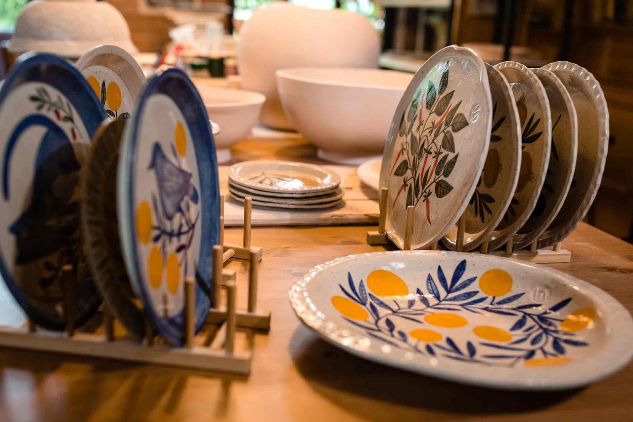 Veselă ceramică cu motive vegetale expusă pe o masă