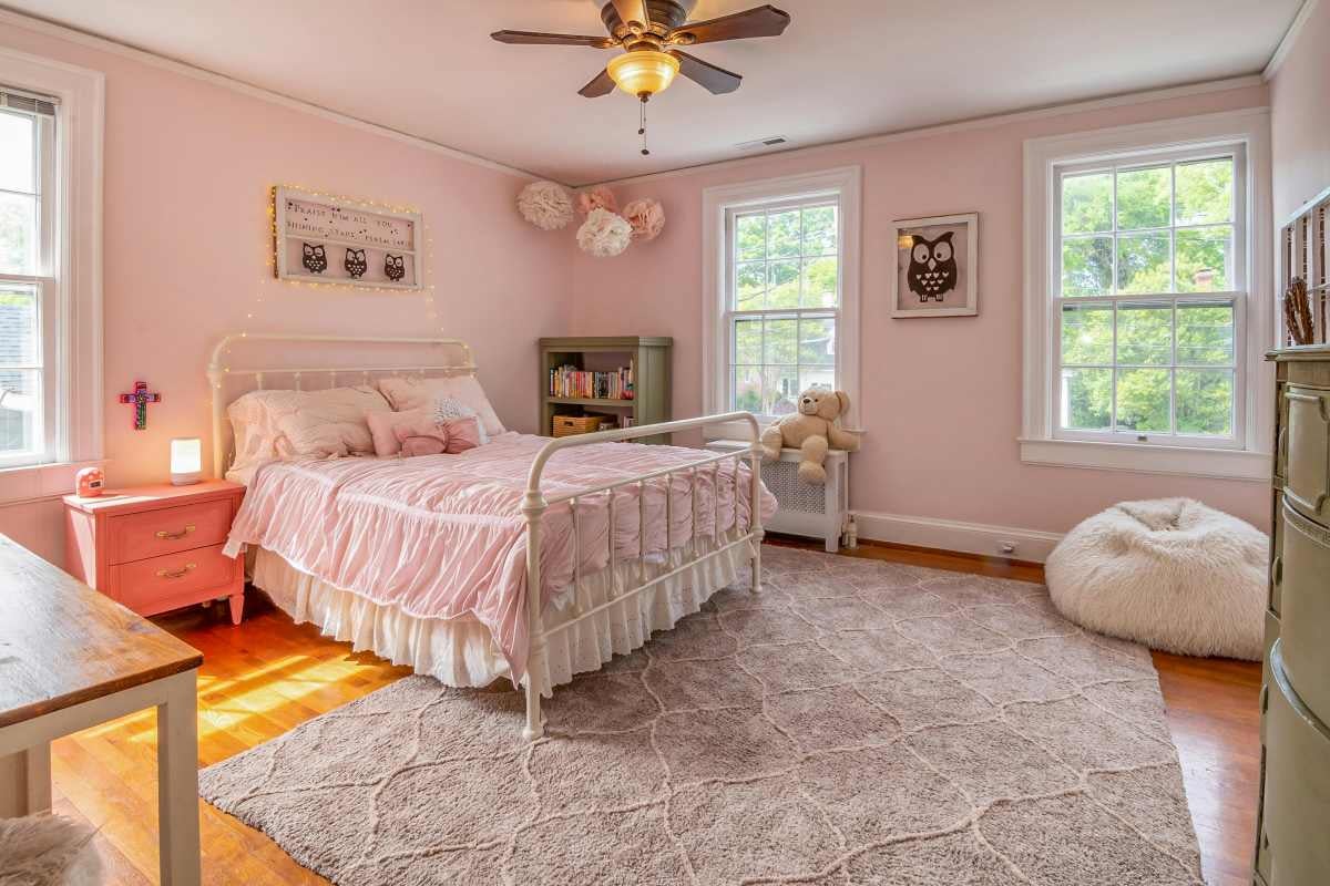 Dormitor luminos cu pat, covor și decorațiuni pentru copii