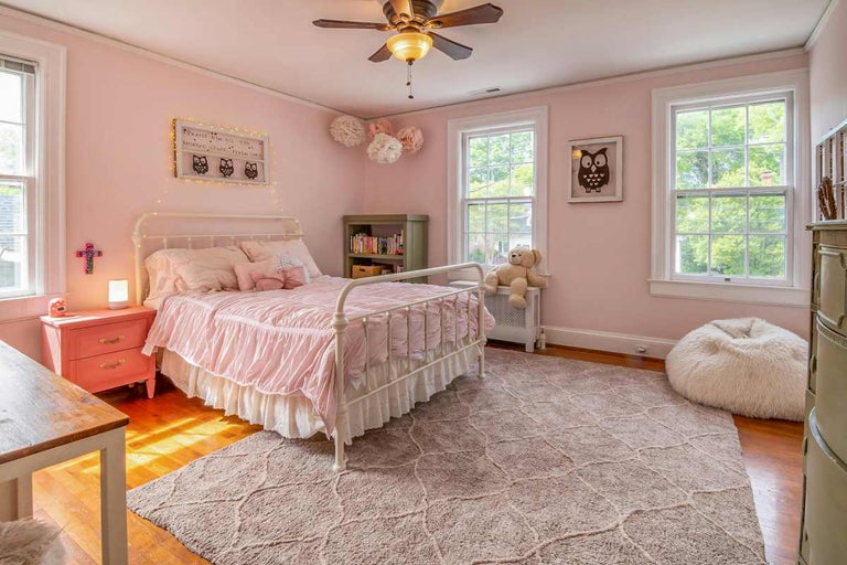 Dormitor luminos cu pat, covor și decorațiuni pentru copii