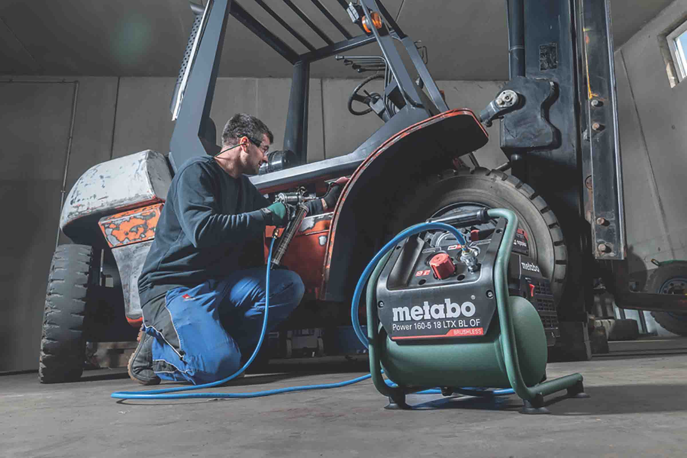 Un bărbat lucrează cu un compresor Metabo Power 160-5 18 LTX BL OF la un motostivuitor.
