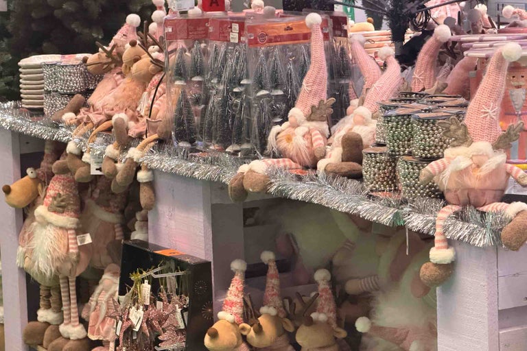 Decoratiuni de Craciun pe rafturi cu spiridusi reni pomi decorativi si lanturi de margele sclipitoare pentru o atmosfera festiva