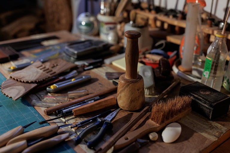 Banc de lucru cu ciocan de lemn, unelte, pensule și recipiente