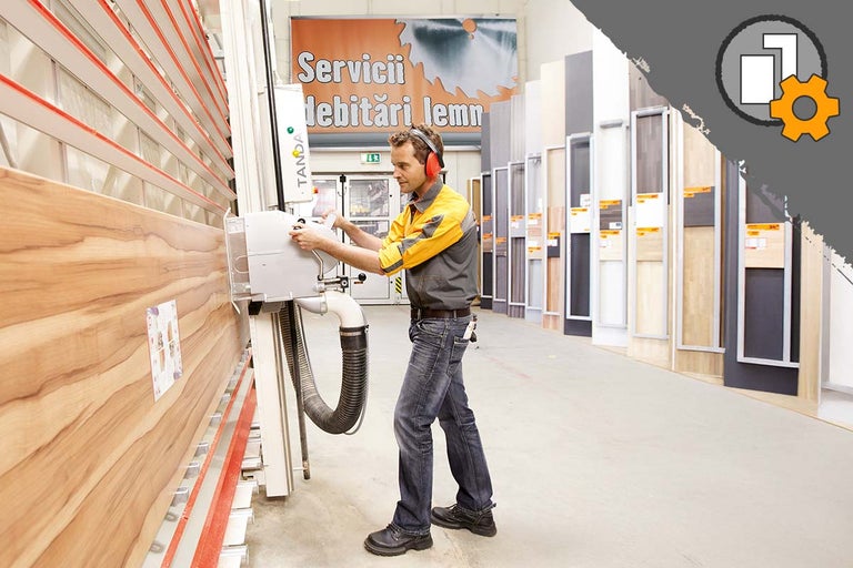 Un bărbat operează un ferăstrău vertical pentru tăierea materialelor lemnoase în magazinul Hornbach.