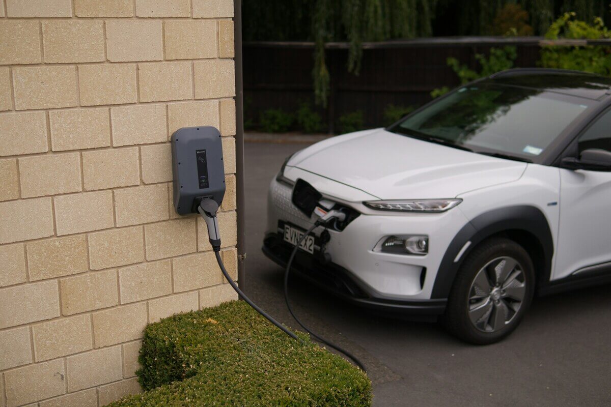 Cutie de încărcare pentru mașini electrice pe un perete al casei cu mașină electrică conectată