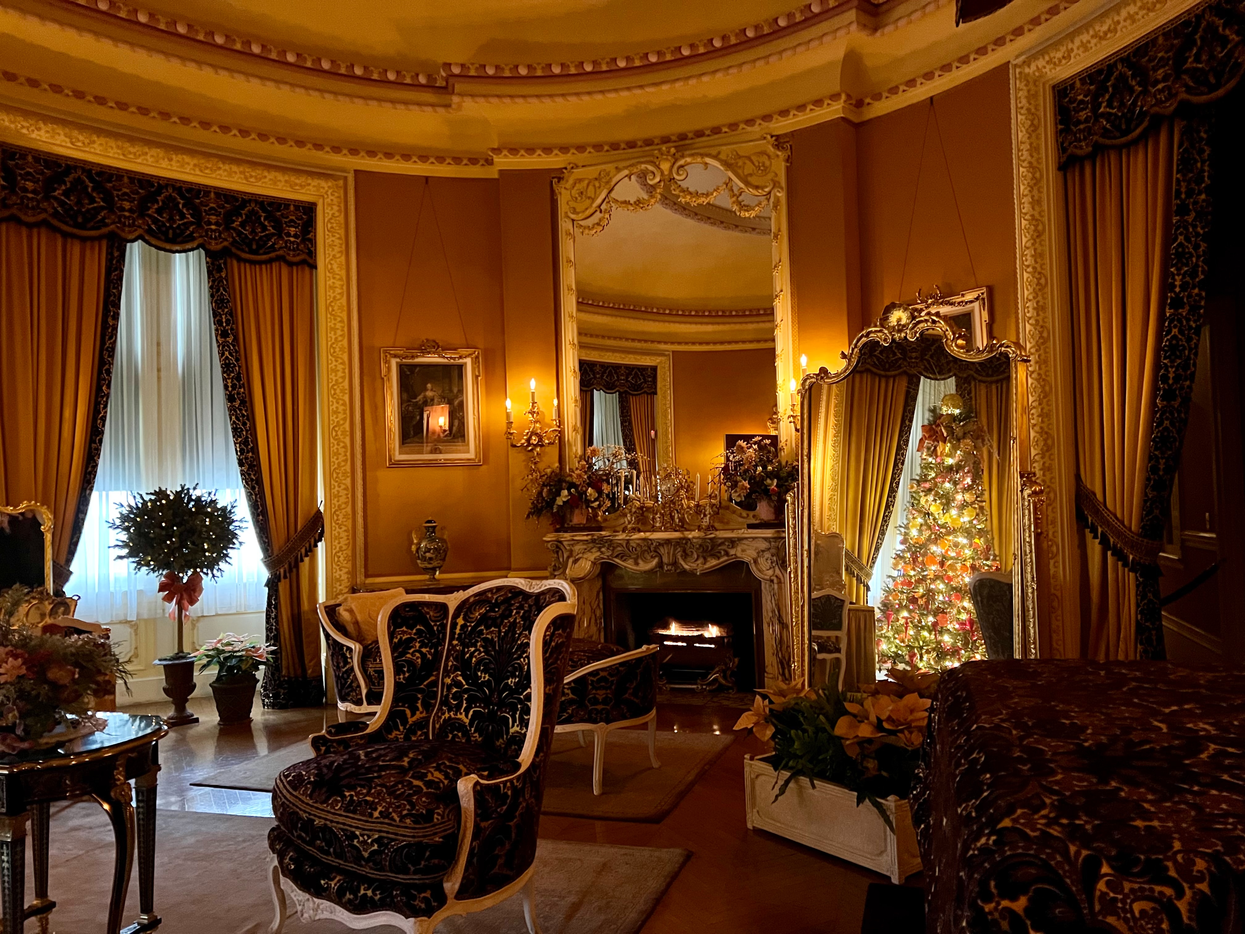 Cameră decorată festiv cu șemineu, oglinzi și fotolii