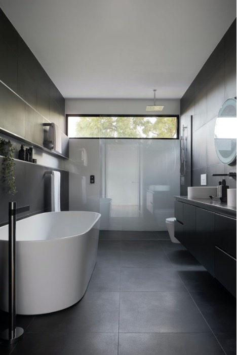 Baie modernă cu cadă freestanding, lavoar și duș