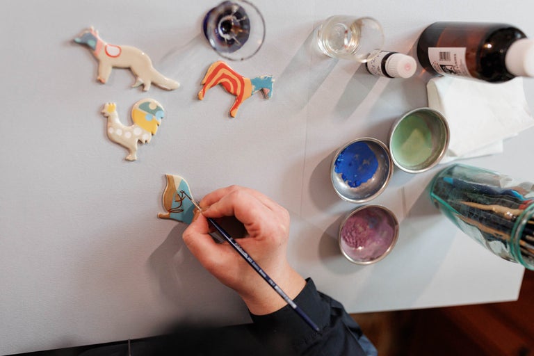 Scenă cu figurine din lemn pictate și materiale de pictură