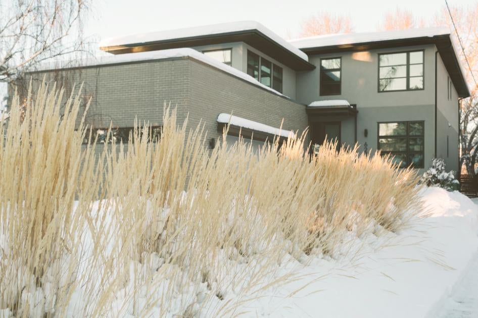 O casă modernă cu iarbă ornamentală în timpul iernii